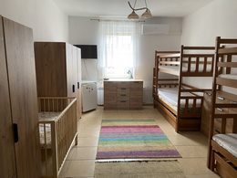 na fotografii widzimy pokój SOW a w nim 2 łóżka piętrowe, łóżeczko dziecięce, 2 szafy, komoda, telewizor dywan, lampa